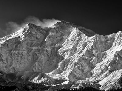 Behold Nanga Parbat in monochromatic splendor, where every crevasse and ridge is magnified by the stark interplay of light and shadow. Known as the ’Killer Mountain’ for its treacherous terrain, this image captures the silent might of the world’s ninth-highest peak in vivid detail. The crisp air and solitude of the Himalayas are palpable, as the photograph etches the mountain’s indomitable spirit against the infinite sky.