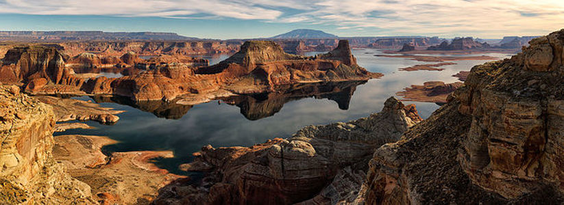 This image captures the stunning panorama of Alstrom Point, showcasing the intricate rock formations and mirror-like reflections on Lake Powell, framed by a vast clear sky.  Ключевые слова: Alstrom Point, Lake Powell, panorama, rock formations, water reflections, vast sky, landscape photography, natural wonders, travel destination, Utah landscapes