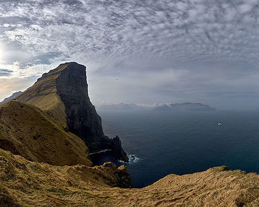 With the Kallur Lighthouse perched atop, this stunning image captures the sheer majesty of the Faroe Islands’ cliffs. The dramatic landscape stretches into the vastness of the North Atlantic, under a sky streaked with clouds, offering a glimpse into the rugged beauty of this remote destination.