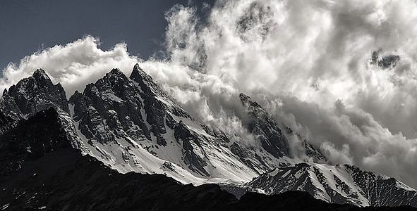 This like monochrome photograph captures the awe-inspiring peaks of Upper Mustang shrouded in billowing clouds. The interplay of light and dark accentuates the rugged textures and immensity of the mountains, inviting viewers to marvel at the grandeur of nature’s creations.
