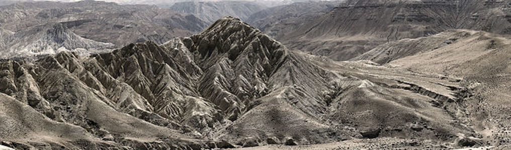 Showcasing the dramatic and rugged landscape of Lo Manthang in Upper Mustang, this panoramic photograph highlights the timeless beauty of the arid ridges and valleys, carved by nature’s elements over millennia, standing as a testament to the Earth’s raw sculptural artistry.