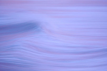 This abstract photograph captures the gentle movement of the ocean in a pastel twilight. The soft focus and elongated exposure create a dreamlike quality, blurring the lines between sea and sky, inviting viewers to a moment of tranquil reflection.