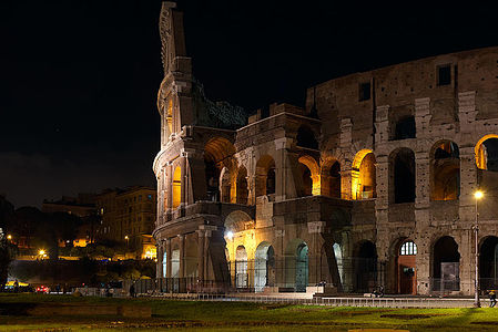 Behold the Colosseum in all its nighttime glory, as the ancient arena is lit up, creating a striking contrast against the dark Roman sky.