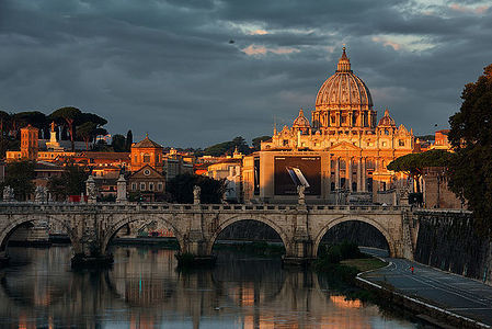 Experience the golden hour’s warm embrace as it illuminates St. Peter’s Basilica, with the historic Ponte Sant’Angelo spanning the Tiber River. Рим.